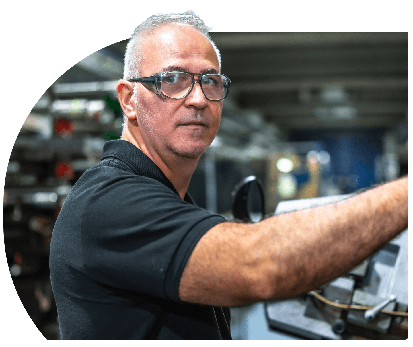 Technician in safety glasses operating manufacturing equipment
